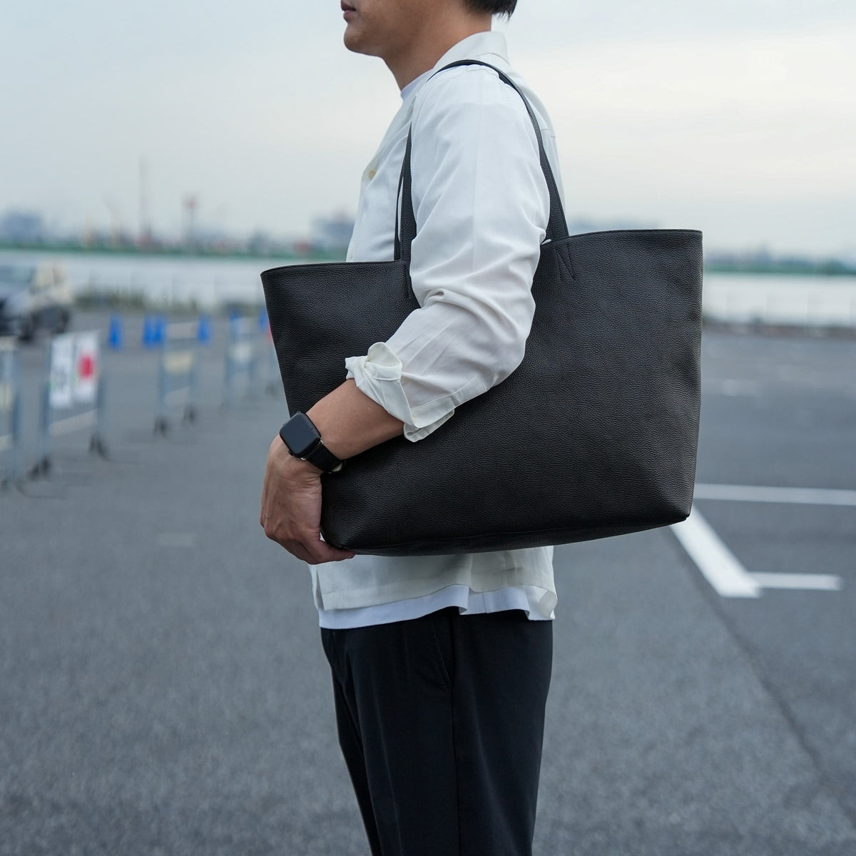 デイリートートバッグを持ったメンズのシティスタイル シンプルで洗練されたトートバッグ