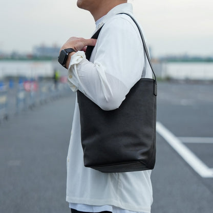 レザーバケットバッグを持ったメンズの日常スタイル シンプルで洗練されたミニショルダーバッグ