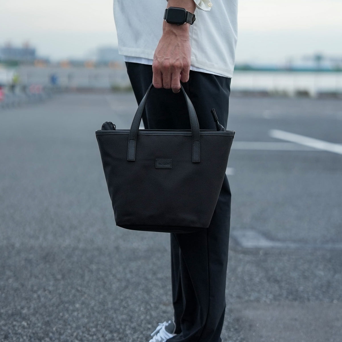 ROUND TOTE BAGを持ったメンズスタイル シンプルで洗練されたラウンド型トートバッグ